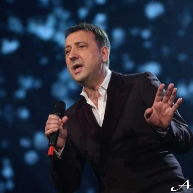 Pevač na sceni drži mikrofon